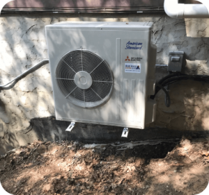 American Standard outdoor heat pump condenser unit installed on a concrete pad against an exterior wall with a Blue Ridge Heating & Air label, heat pump installation in Hendersonville, NC